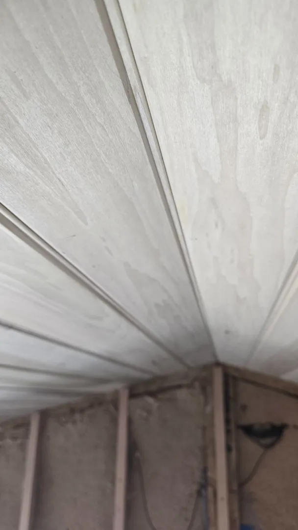 Close view of shaped ceiling boards meeting at a curved transition.