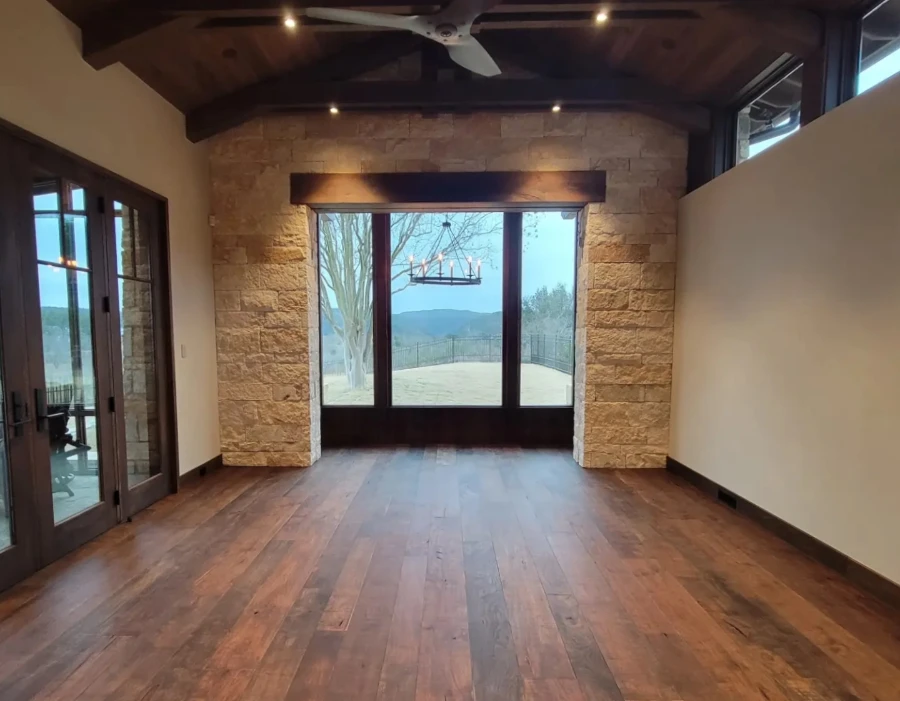 Finished Perryton interior with stained timber ceiling, stone walls, wood flooring, and integrated lighting.