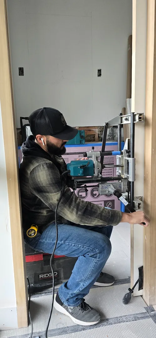 Craftsperson fitting concealed door hardware at Las Lomas.