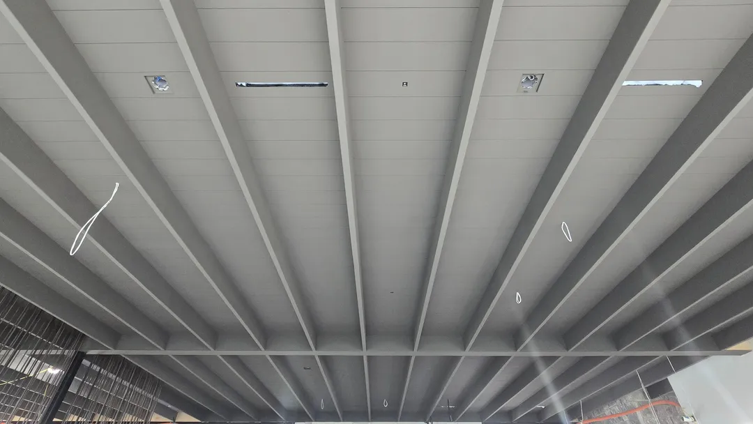 Painted beam-and-board ceiling system with integrated lighting details.