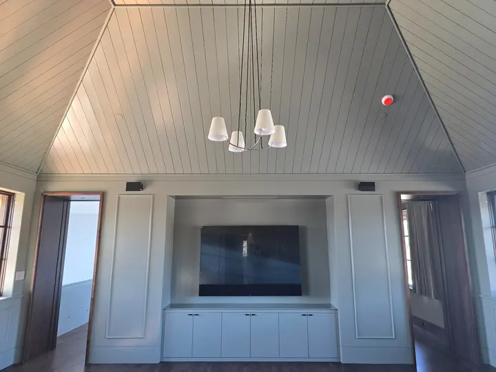 Integrated media wall, casework installation, paneled ceiling, and framed wall details at Stoneridge.