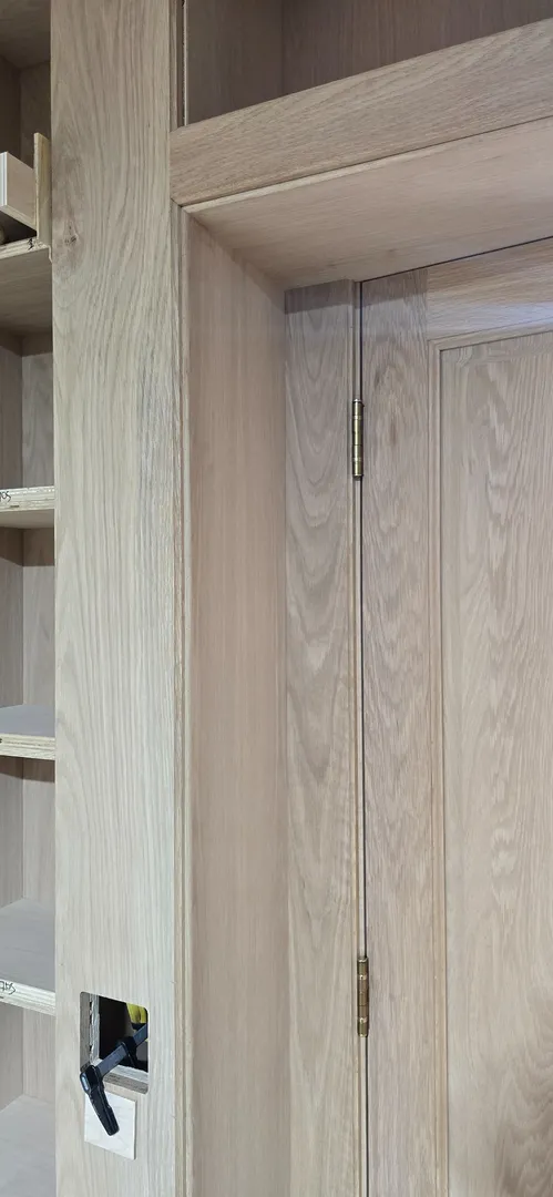 Concealed hinge and tightly fitted white oak casing detail.
