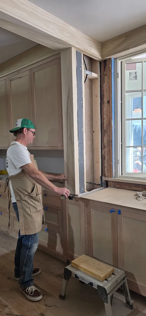 White oak window trim and wall paneling being finished in place.