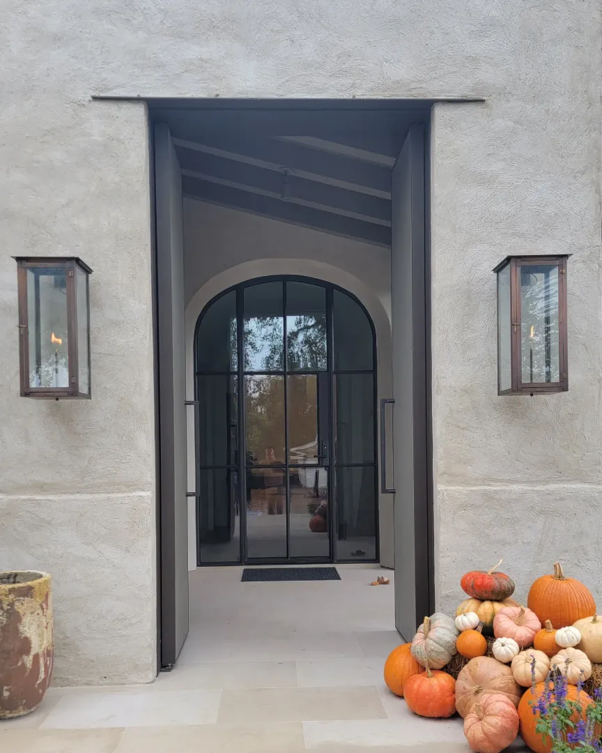 Custom entry door opened to reveal an arched glazed passage beyond.